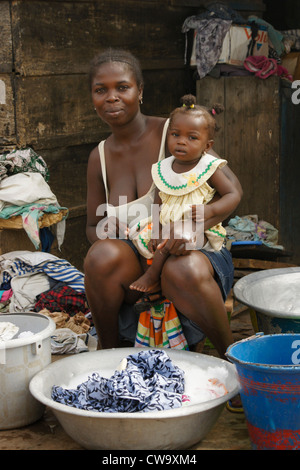 Femme avec bébé le lavage des vêtements, Elmina, Ghana Banque D'Images