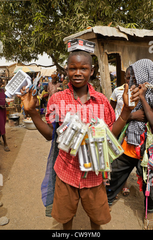 Garçon vente de lampes de poche et des piles en marché, Sirigu, Ghana Banque D'Images