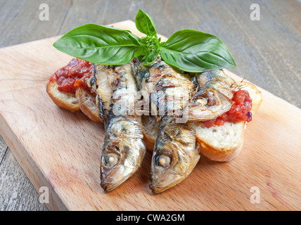 Les sardines avec une sauce tomate aux fines herbes avec du pain français Banque D'Images