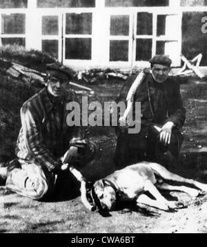 Les anciens prisonniers au camp de concentration de Dachau à genoux par le chien qu'ils ont tué avec des gourdins. Les détenus vivaient dans la crainte d'être nourri à Banque D'Images