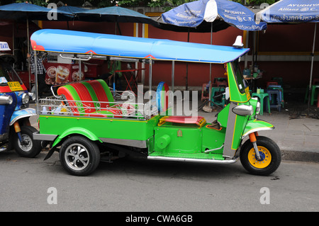 Smart lime green tuk-tuk, route, occupé à soi, au large de la route Sukhumvit, Bangkok. Banque D'Images