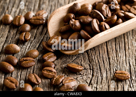 Grains de café dans le scoop en bois ancien fond de bois Banque D'Images