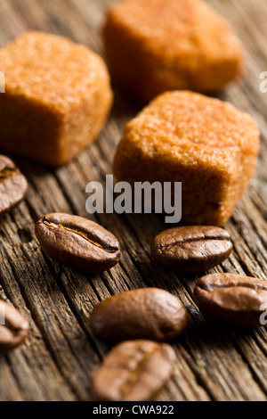 Les grains de café avec du sucre brun cubes on wooden table Banque D'Images