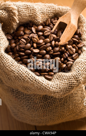 Les grains de café en sac de toile avec du scoop Banque D'Images