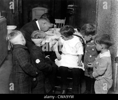 Les enfants qui reçoivent des vaccins par le Dr John Davies, 1930.. Avec la permission de la CSU : Archives / Everett Collection Banque D'Images