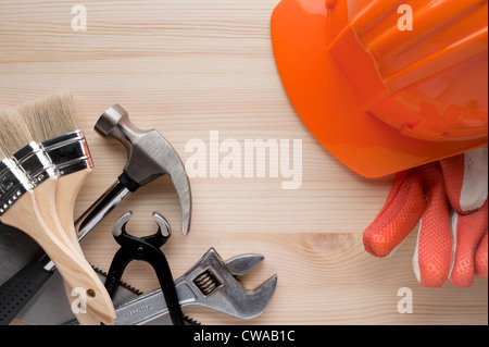 Casque, gants et certains outils assortis disposées sur une surface en bois. La construction, la réparation ou l'amélioration de l'arrière-plan. Banque D'Images