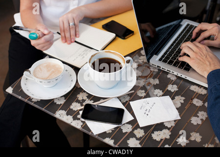 Businesspeople in cafe, man woman writing Banque D'Images