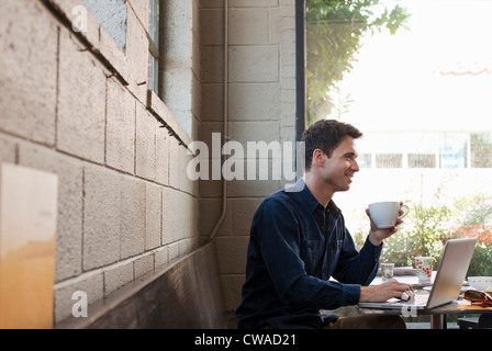 Businessman using laptop in cafe Banque D'Images