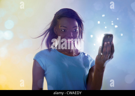 Teenage girl using cellphone lumineux Banque D'Images