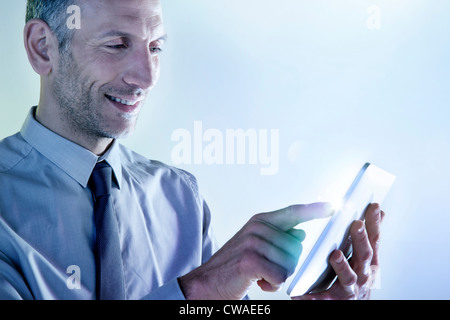 Businessman using digital tablet avec lumières Banque D'Images
