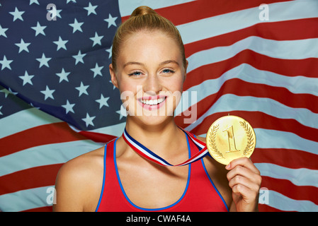 Jeune femme en face de USA drapeau avec médaille d'or Banque D'Images