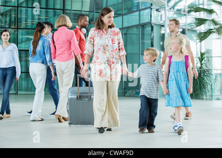 Mère et enfants de marcher à travers l'airport Banque D'Images