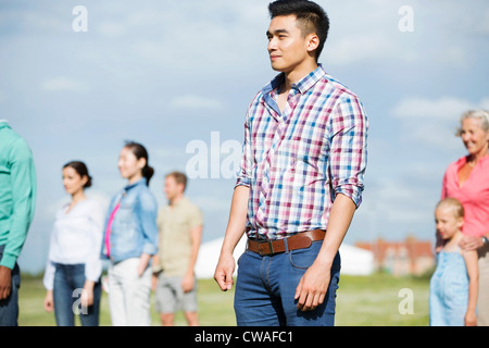Jeune homme debout devant un groupe de personnes à l'extérieur Banque D'Images