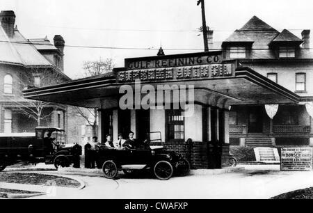 Trois hommes dans un polies Chalmers touring car attente de service à la Cour suprême Oil Co., le premier drive-in gas Banque D'Images