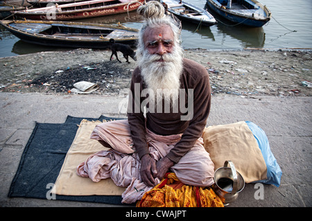 Sadhu assis sur les ghats de Varanasi, Inde Banque D'Images