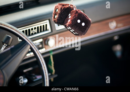 Furry dice hanging in car Banque D'Images