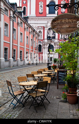 Tables à l'extérieur d'un café dans une rue de la place du marché, Stary Rynek, à Poznan, en Pologne avec l'Église Fara à la fin. Banque D'Images