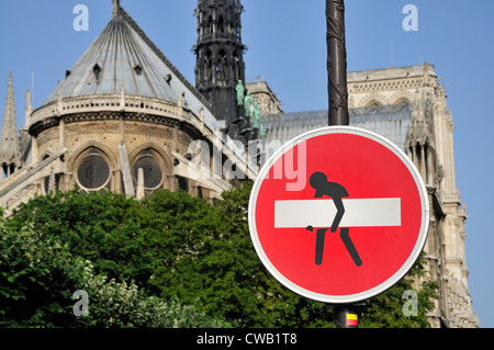 Paris, France. Aucun signe d'entrée par la cathédrale Notre Dame - 'amélioré' par Clet Abraham - homme emportant la barre blanche Banque D'Images