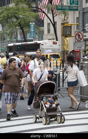 Jeune maman pousse bébé en poussette le long de la 5e Avenue à New York City Banque D'Images