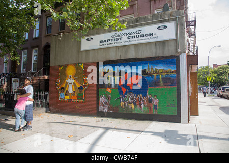 Fresque avec le thème "Nous sommes tous une famille' sur une église baptiste dans le quartier de Bed-Stuy Brooklyn, New York. Banque D'Images