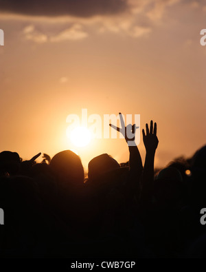 Le soleil se couche sur la foule. 2 mains en silhouette la V (la victoire). V Festival le 19/08/2012 à Hylands Park, Chelmsford. Photo par Julie Edwards Banque D'Images