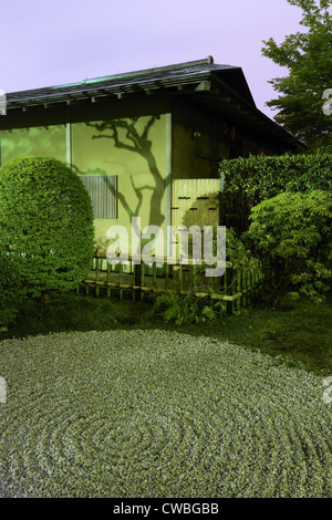 Mur de la maison japonaise avec l'ombre des arbres et traditionnel motif de cercles sur le sable en jardin zen par nuit, Tokyo Japon Banque D'Images