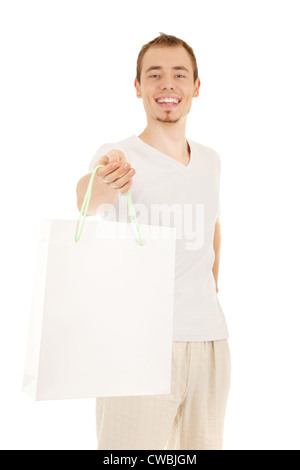Smiling handsome man est la présentation de cadeaux sac de papier blanc, isolé sur blanc. Se concentrer sur la main. Banque D'Images