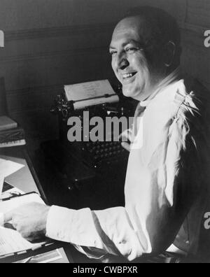 Producteur de films, Val Lewton (1904-1951), travaillant à son bureau, avec une main sur un script et l'autre sur une machine à écrire. Ca. 1945. Banque D'Images
