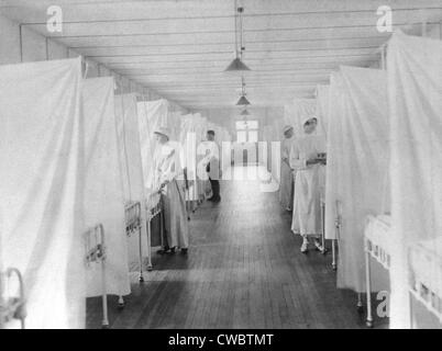 L'épidémie de grippe espagnole de 1918-1919. Les infirmières et infirmiers s'en tenir à lits séparés par feuilles pour isoler les patients dans le Banque D'Images