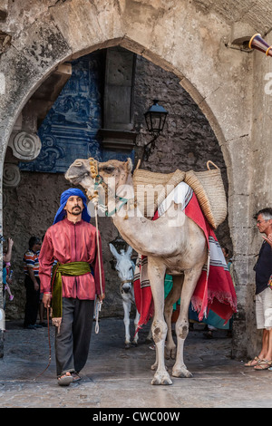 L'homme maure avec dromadaire dans une reconstitution d'une foire médiévale à Óbidos, Portugal. Banque D'Images