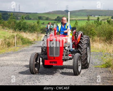 La conduite d'un amateur de vintage rouge tracteur Massey Ferguson 35 au cours d'une machine et de tracteur Vintage Ayrshire Club road run Banque D'Images