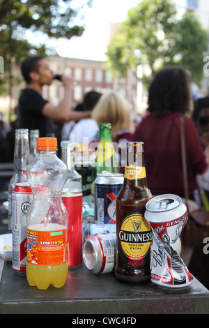 Table avec bouteille vide et canettes de boisson de détritus rue Banque D'Images