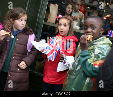 Les enfants de manger des hamburgers dans la rue à des célébrations du Jubilé de diamant à Londres 2012 Banque D'Images