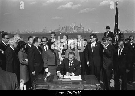 LBJ's Great les programmes de la société. Le Président Lyndon Johnson signe la Loi sur l'Immigration sur Liberty Island dans le port de New York. L Banque D'Images