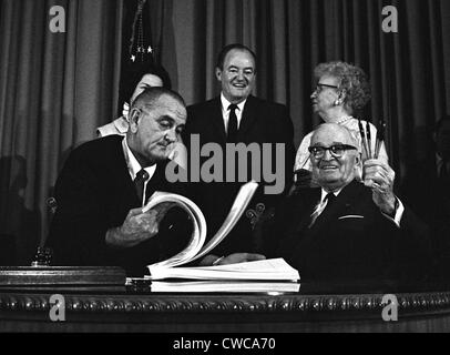 LBJ's Great les programmes de la société. Le Président Lyndon Johnson signe la loi d'assurance-maladie avec l'ancien président Harry Truman, le premier Banque D'Images