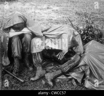 Guerre du Vietnam. Deux Marines américains las bataille prendre une pause, la pluie et tout, pendant l'opération Bold Mariner. La mission de l'opération a été Banque D'Images