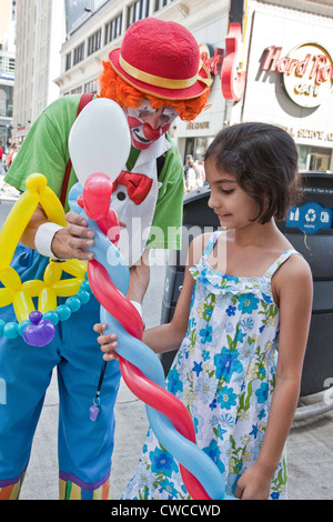 Clown ballons est divertissant une petite fille sur la rue Yonge à Toronto,Ontario;Canada Banque D'Images