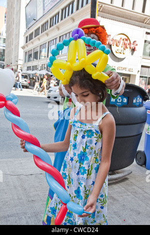 Clown ballons est divertissant une petite fille sur la rue Yonge à Toronto,Ontario;Canada Banque D'Images