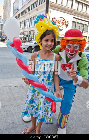 Clown ballons est divertissant une petite fille sur la rue Yonge à Toronto,Ontario;Canada Banque D'Images