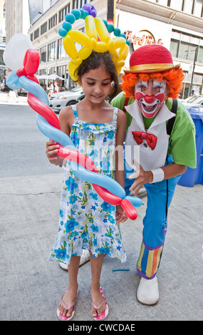 Clown ballons est divertissant une petite fille sur la rue Yonge à Toronto,Ontario;Canada Banque D'Images