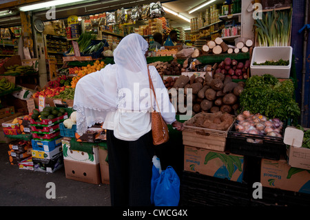 Asian woman buying vegetables in Marché de Brixton Banque D'Images