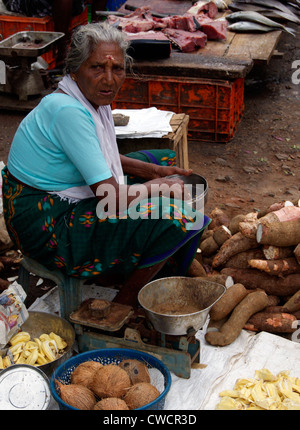 Vieux village de femmes qui vend des légumes sur la route de l'alimentation ayant ses sandwichs de poissons à proximité d'une boutique ouverte au Kerala Inde Banque D'Images