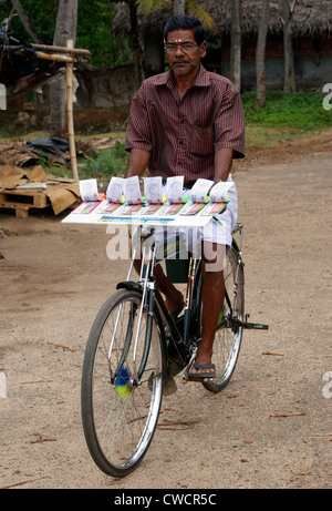 Vendeur de billets de loterie équitation location scène de Kerala, Inde.Le cycle homme utilisé pour vendre des billets de loterie en village autochtones Banque D'Images