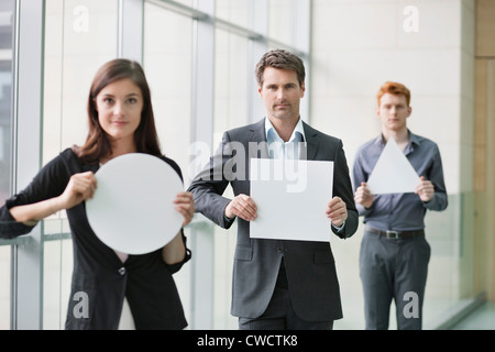 Les dirigeants d'holding blank des pancartes dans un bureau Banque D'Images