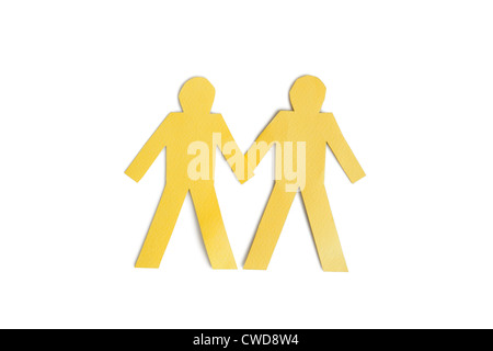 Découpe du papier jaune deux figures holding hands over white background Banque D'Images