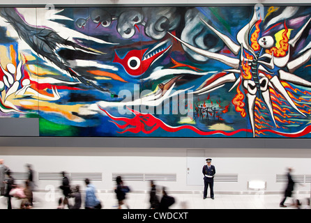 Un garde de sécurité se place en avant du 30 mètres de long appelé "peinture yrth de demain' en gare de Shibuya, Tokyo, Japon Banque D'Images