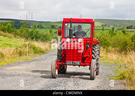 La conduite d'un amateur International Harverster rouge vintage tracteur pendant une Ayrshire Vintage le tracteur et la machine Club road run. Banque D'Images