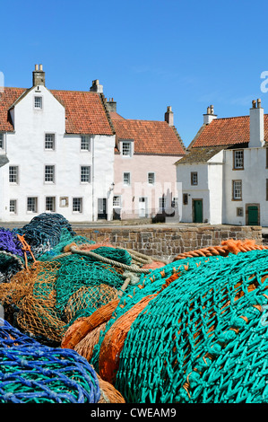 Pittenweem, East Neuk de Fife, Scotland, UK. Les filets de pêche empilés sur le quai avec des maisons d'un style typique de la région. Banque D'Images