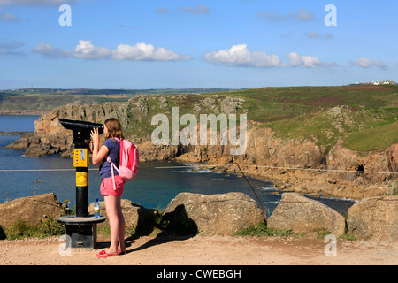 Une jeune fille voir la côte de Cornouailles à Lands End grâce à un pay-per-view telescope Banque D'Images