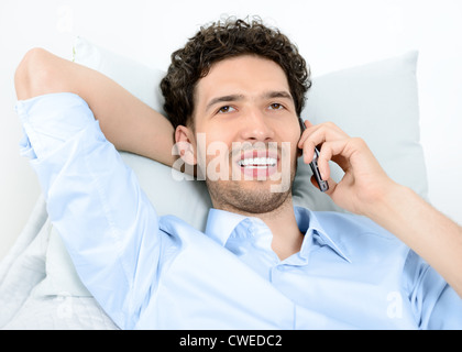 Young handsome man talking on mobile phone moderne. Studio shot. Banque D'Images